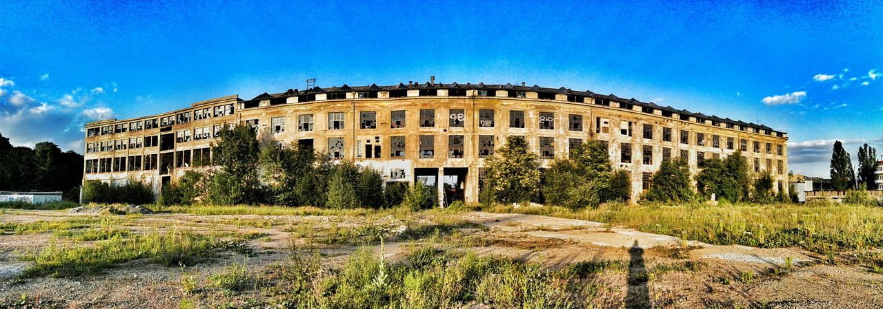 architecture, built structure, building exterior, blue, sky, old, history, grass, abandoned, building, old ruin, damaged, day, clear sky, the past, tree, sunlight, low angle view, travel destinations, outdoors