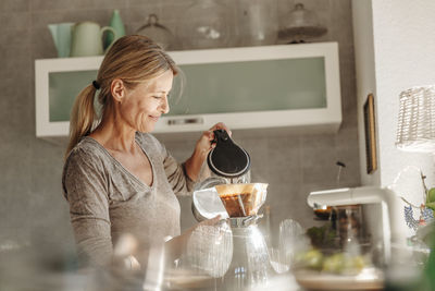 Woman holding drink at home