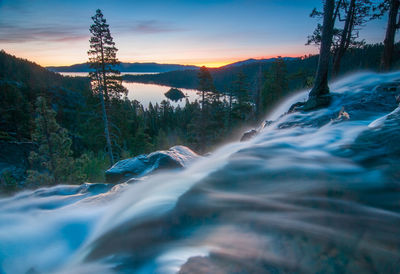 Scenic view of river against sky at sunset