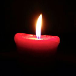 Close-up of lit candle in dark room