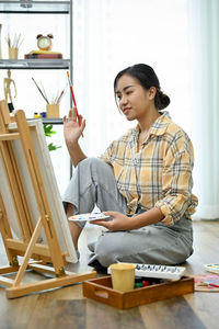 Side view of man using laptop while sitting on table