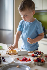 Portrait of cute boy eating food at home