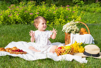 Portrait of smiling young woman sitting on field