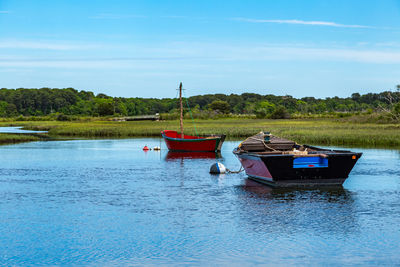 Boat moored in lake against sky