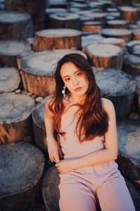 Portrait of a young woman sitting on wood