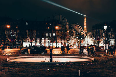 Group of people in illuminated city at night