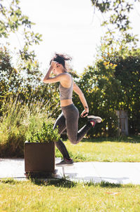 Full length of woman in mid-air against trees