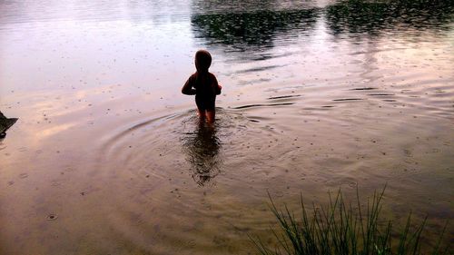 Rear view of a boy in calm sea