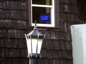 Low angle view of illuminated lamp on wall