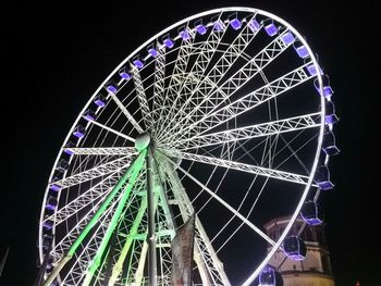 Low angle view of illuminated ferris wheel against sky at night