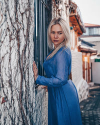 Portrait of woman standing by tree trunk