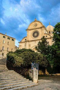 Temple against building and trees against sky