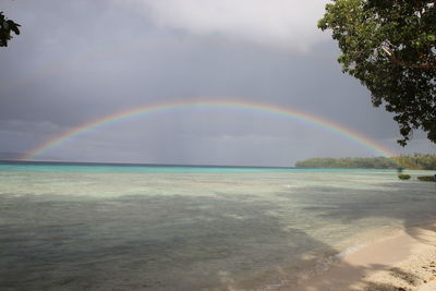 Scenic view of rainbow over sea against sky