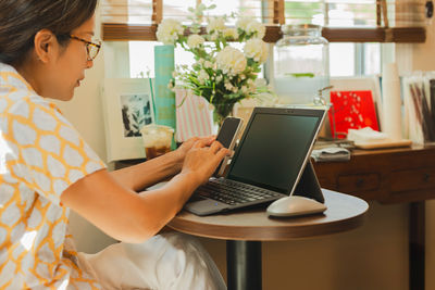 Young woman using laptop at table