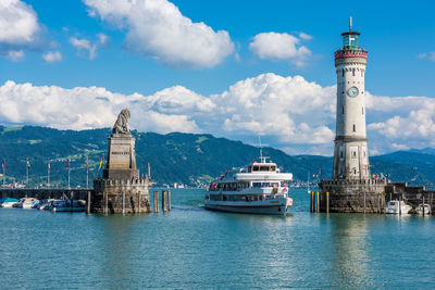 Sailboat on sea by buildings against sky