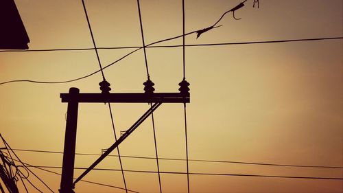 Low angle view of silhouette suspension bridge against sky during sunset