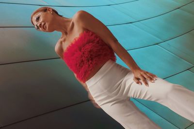 Full length of young woman  stands near a mirrored wall