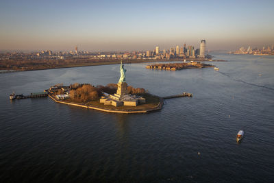 The statue of liberty stands tall over new york harbor, nyc.