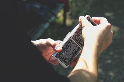 Midsection of man holding cards