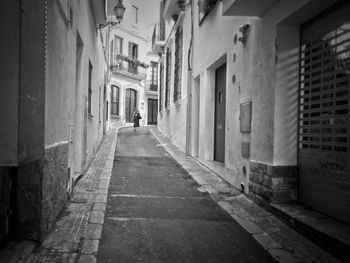 Rear view of man walking on street in city