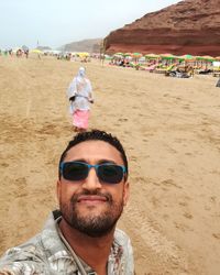 Portrait of young man wearing sunglasses on beach