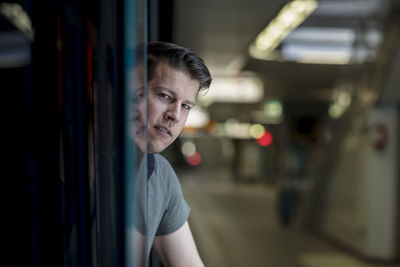 Portrait of young man entering in train at railroad station