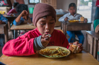 Boy eating food on table