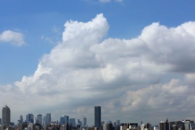 Urban skyline against cloudy sky