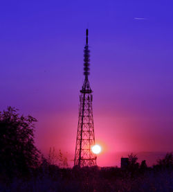 Low angle view of communications tower against sky at sunset