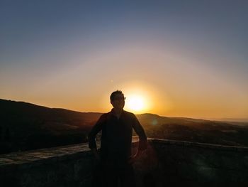 Portrait of young man standing against sky during sunset