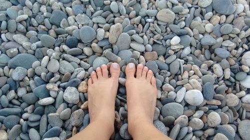 Low section of person legs on pebbles