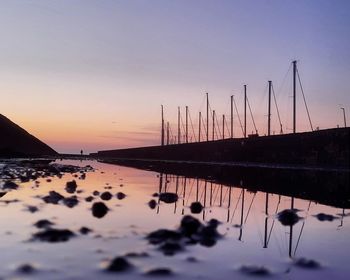 Silhouette sailboats in sea against sky during sunset