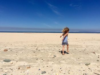 Full length of girl running on beach against sky