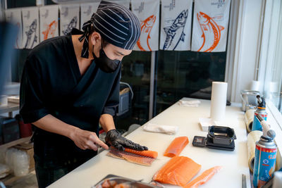 Side view of japanese chef making salmon sushi at resturant 