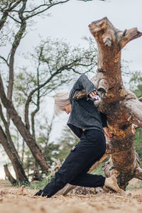 Man sitting on tree trunk in forest