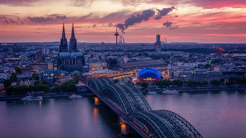 Illuminated buildings in city at sunset