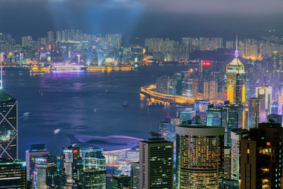 Illuminated buildings in city against sky at night