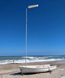 Scenic view of beach against clear blue sky