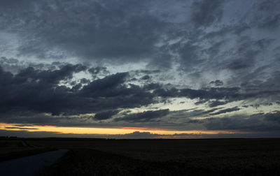 Scenic view of dramatic sky over field