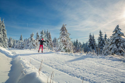 Person walking on snowcapped mountain against sky during winter