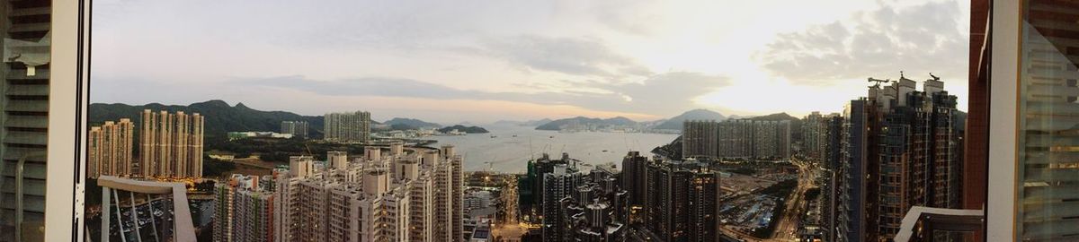 Panoramic view of cityscape against cloudy sky