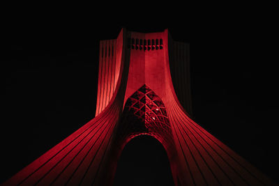 Low angle view of illuminated bridge against black background