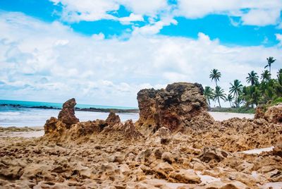 Rocks on beach against sky