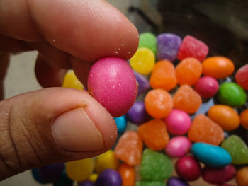 A hand holding a colorful candy