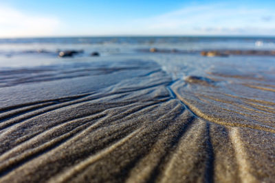 Surface level of sand on beach against sky