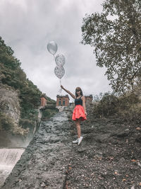 Girl standing by plants against sky