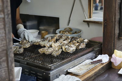 Midsection of person preparing food for sale at restaurant