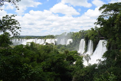 Scenic view of waterfall against sky