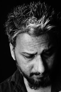 Close-up portrait of man against black background