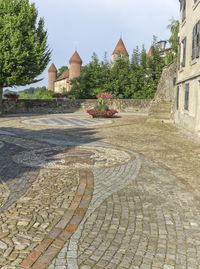 Cobblestone street amidst buildings against sky